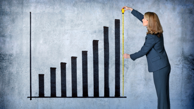 Une femme mesure un graphique symbolisant la croissance de l'entreprise